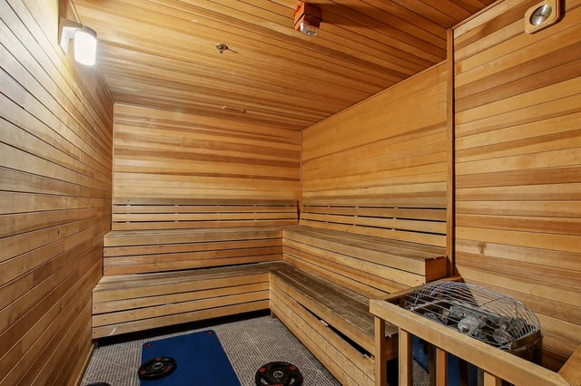 Wooden sauna with benches heating stones and weights Sauna at The Station Alafaya in Orlando Student Accommodation