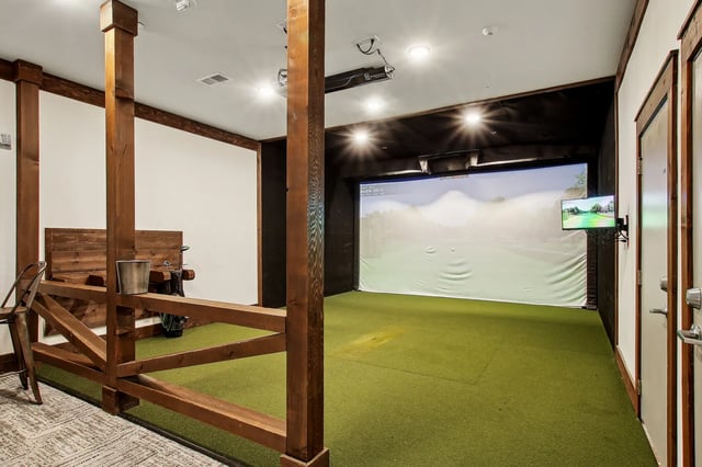 Golf simulator with large screen and turf area playing area at The Station Alafaya in Orlando Student Accommodation