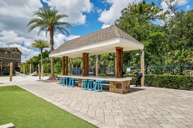Covered bar with blue stools and grills outdoor area at The Station Alafaya in Orlando Student Accommodation
