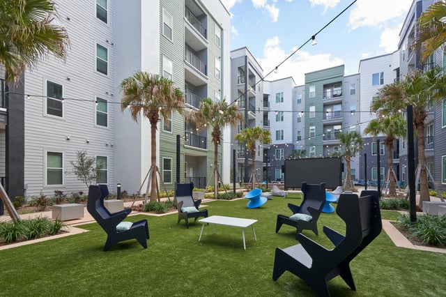 Chairs tables and outdoor cinema screen courtyard exterior at The Accolade Collegiate Village West in Orlando Student Accommodation
