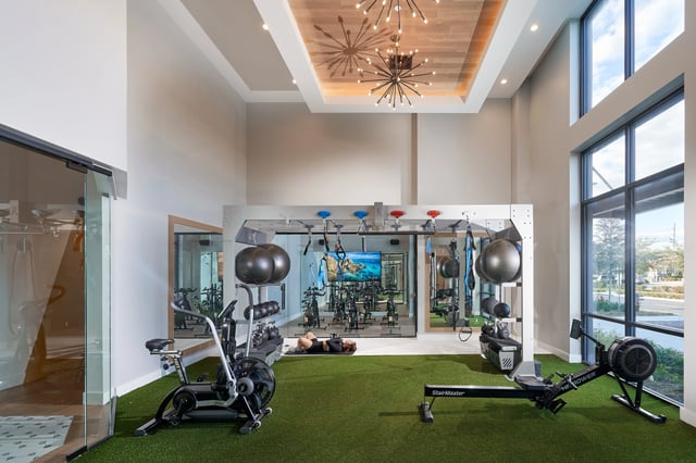 Fitness equipment workout machines and person gym playing area at The Accolade Collegiate Village West in Orlando Student Accommodation