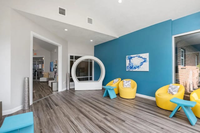 Yellow chairs blue tables modern art living room at Lexington Crossing in Gainesville Student Accommodation