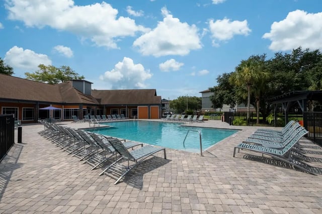 Pool with lounge chairs and building exterior at Lexington Crossing in Gainesville Student Accommodation