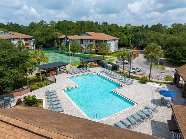 Pool tennis court and apartment buildings exterior at Lexington Crossing in Gainesville Student Accommodation
