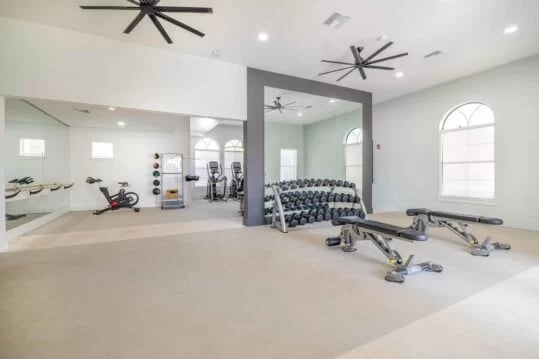 Gym equipment includes stationary bikes weight racks and benches. Fitness center at The Lofts Orlando in Orlando Student Accommodation