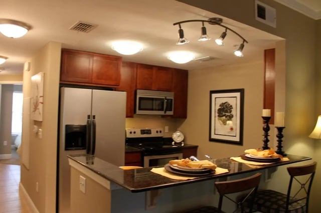 Stainless steel refrigerator microwave cabinets stools kitchen at Upper Westside Apartments in Gainesville Student Accommodation