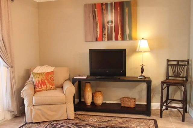Armchair television console vase basket bar stool living room at Upper Westside Apartments in Gainesville Student Accommodation