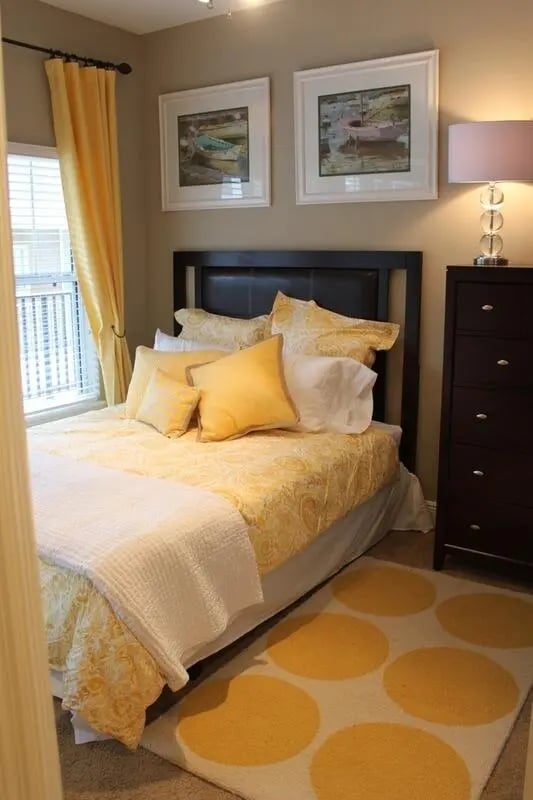 Yellow patterned bed with pillows and rug bedroom at Upper Westside Apartments in Gainesville Student Accommodation