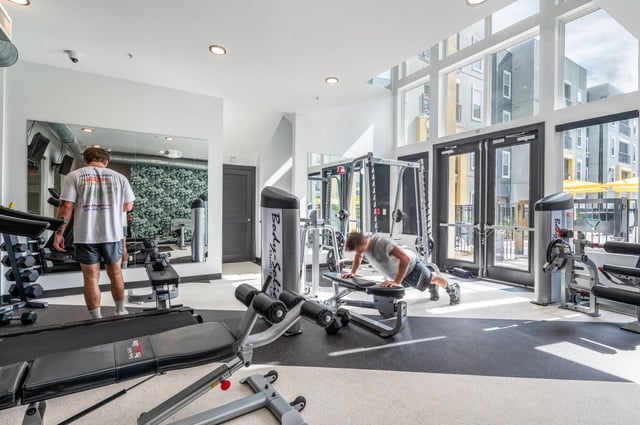 Gym equipment and man doing pushups Gym area at The Aves @ Twelve 100 in Orlando Student Accommodation