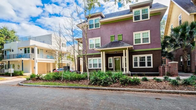 Purple and white apartment buildings with balconies exterior at Lyons Corner Townhomes in Gainesville Student Accommodation
