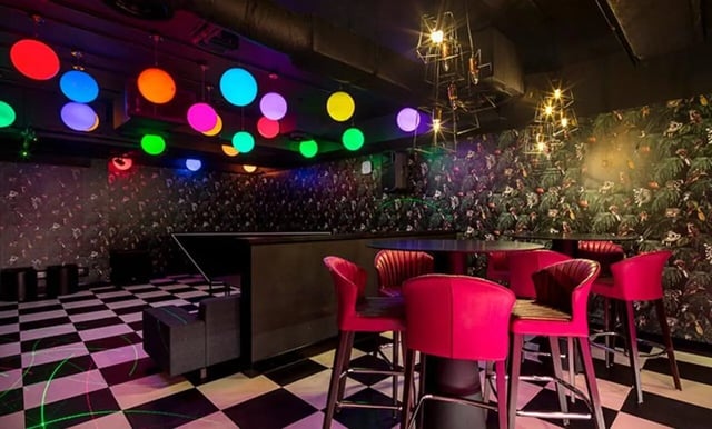 Bar with pink chairs checkered floor colorful lights playing area at Collegiate Eclipse in Cardiff Student Accommodation