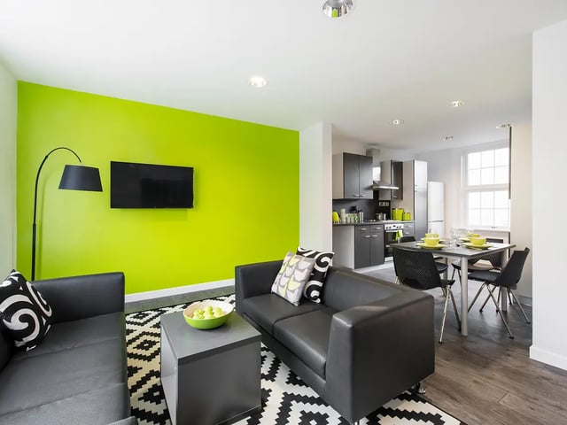 Two black sofas kitchen and dining area living room at Yugo Crescent Place in Southampton Student Accommodation