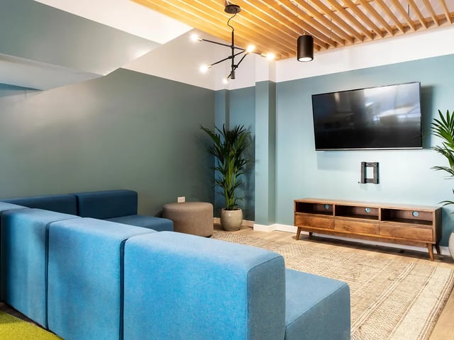 Blue sectional sofa television wooden media unit living room at Yugo Crescent Place in Southampton Student Accommodation