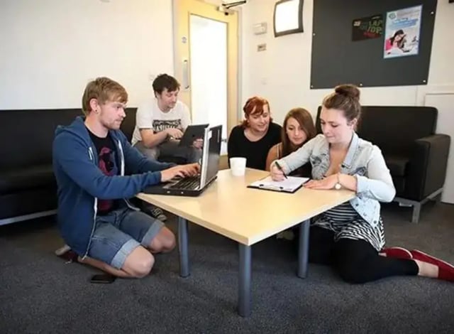 Students work on laptops at a table Living room at Denton Holme in Carlisle Student Accommodation