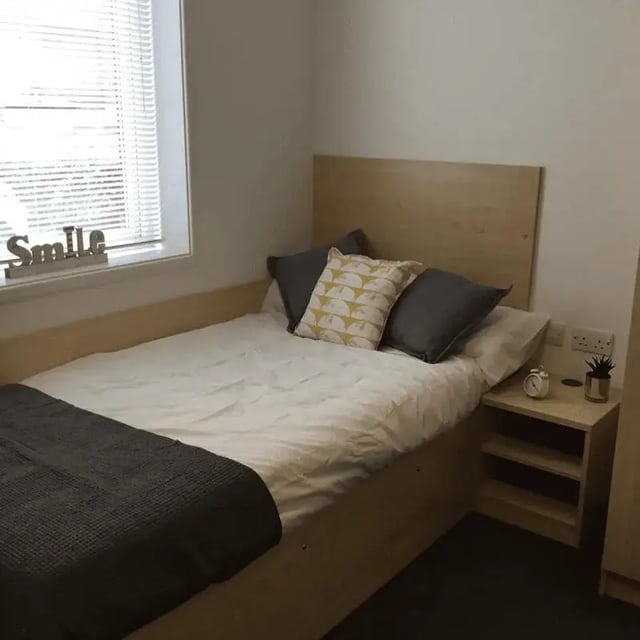 Bed pillows blanket and bedside table bedroom at Denton Holme in Carlisle Student Accommodation