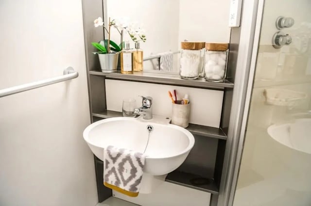 Sink with towel toiletries and shower visible bathroom at McDonald Road in Edinburgh Student Accommodation