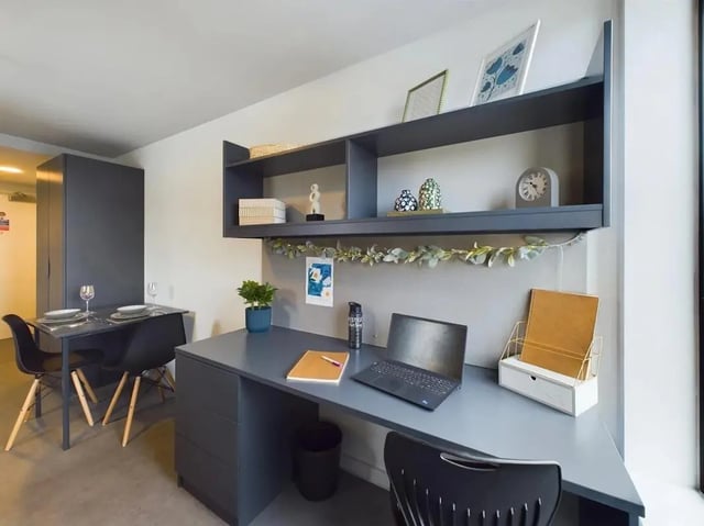 Desk with laptop plants and dining table study area at Ravilious House in Brighton Student Accommodation