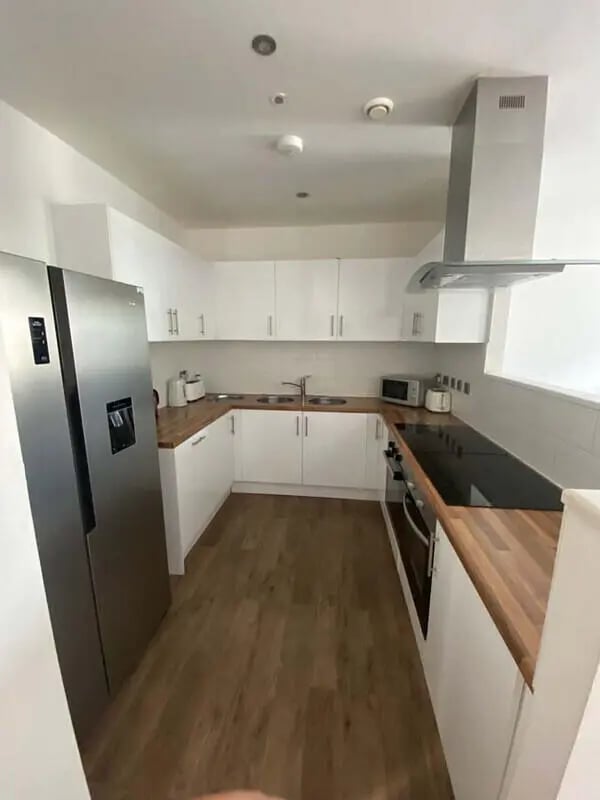 Stainless steel fridge white cabinets wood counters kitchen at St Mary's House Sheffield in Sheffield Student Accommodation