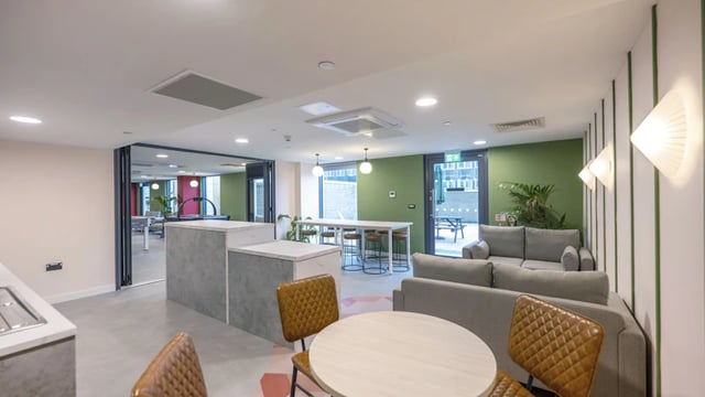 Sofa tables chairs kitchen island communal area at The Edge in Belfast Student Accommodation