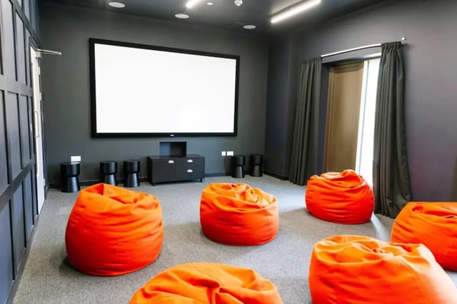 Orange beanbags facing projector screen cinema room at Bankside Student Living - Guildford in Guildford Student Accommodation