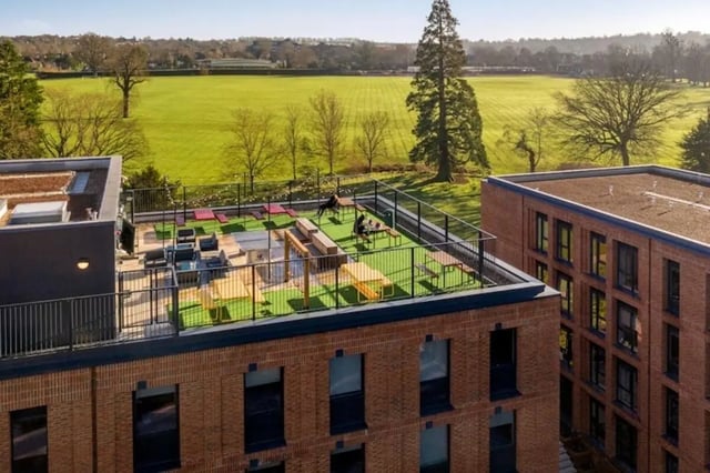 Rooftop lounge area with seating and tables outdoor living area. at Guilden Village in Guildford Student Accommodation