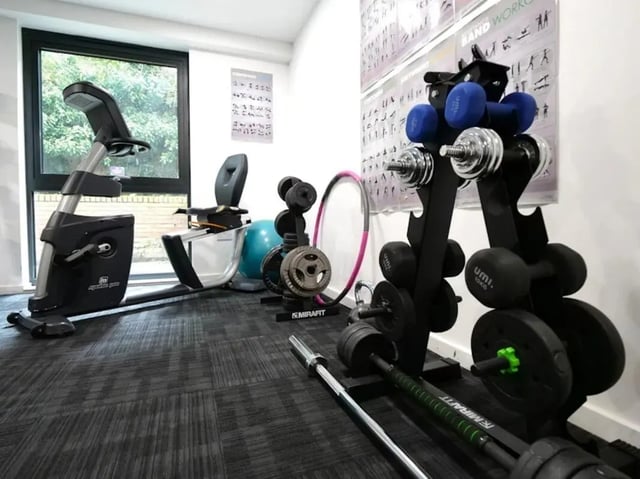 Gym equipment including exercise bikes dumbbells and barbells playing area at Gateway Apartments in Edinburgh Student Accommodation