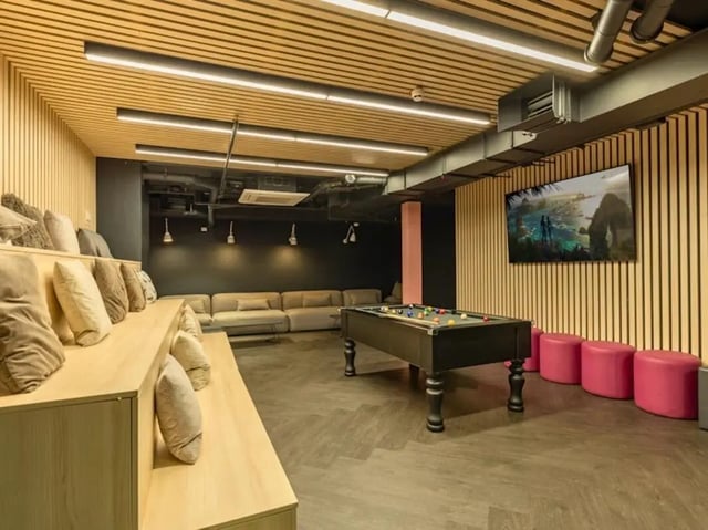 Pool table sectional sofa with pillows and TV playing area at Crown House Brighton in Brighton Student Accommodation