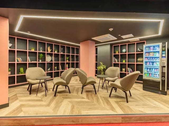 Chairs bookshelves and vending machine communal area at Crown House Brighton in Brighton Student Accommodation