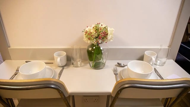 Table setting with flower vase and chairs dining area at Collegiate St James Street in Portsmouth Student Accommodation