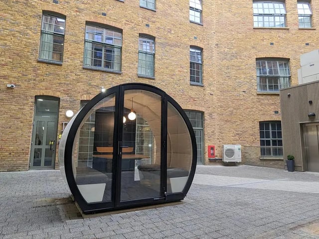 Glass pod with seating and table outdoor room at Depot Point in London Student Accommodation