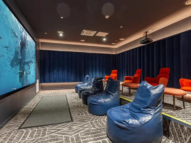 Beanbag chairs and orange chairs cinema room at Yugo St. Crispin's House in Norwich Student Accommodation