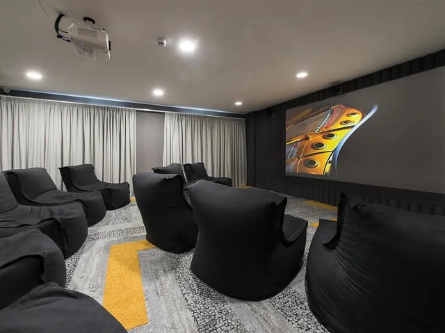 Black beanbag chairs projector screen and curtains cinema room at Yugo Beckley Point in Plymouth Student Accommodation