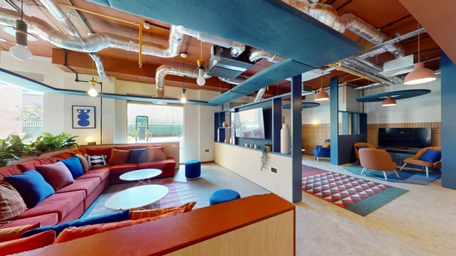 Red sectional sofa with blue pillows lounge area at Enso in Colchester Student Accommodation