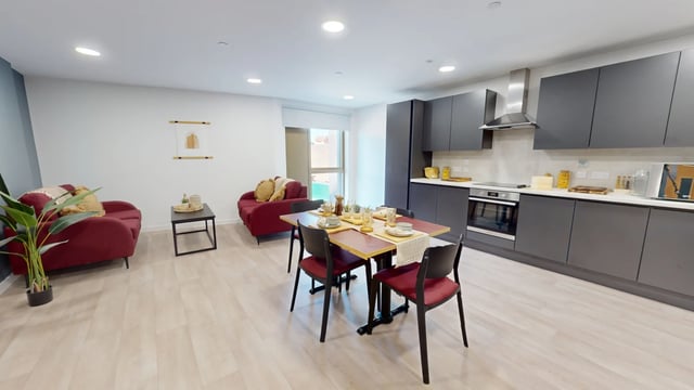 Red sofas dining table kitchen cabinets living room kitchen at Enso in Colchester Student Accommodation
