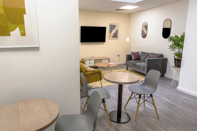 Living area with sofa armchair tables and chairs living room at The City Arcade - Exeter in Exeter Student Accommodation