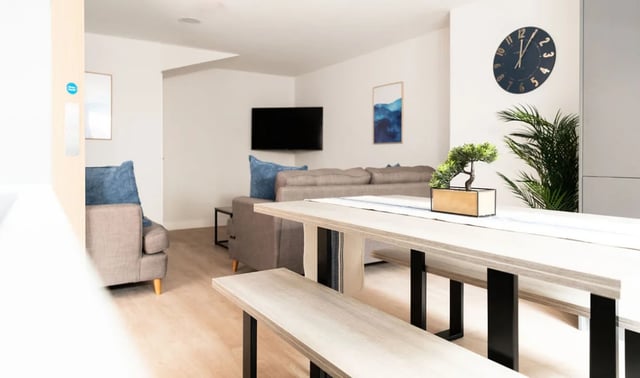 Dining table benches sofa television living area at Boutique Student Living - Exeter in Exeter Student Accommodation
