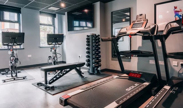 Treadmills exercise bikes dumbbell rack workout gym at Boutique Student Living - Exeter in Exeter Student Accommodation