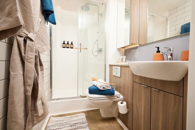 Robe toilet shower sink and towels bathroom at Vita Student Pebble Mill in Birmingham Student Accommodation