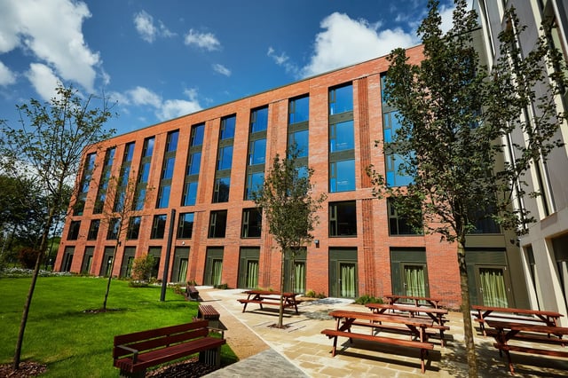 Modern brick building with picnic tables exterior at Vita Student Pebble Mill in Birmingham Student Accommodation