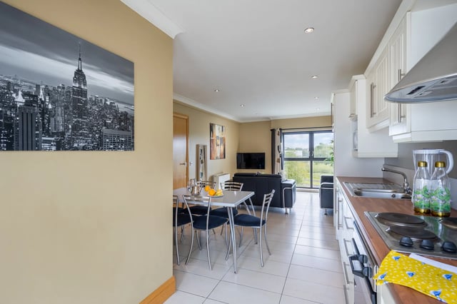 Dining table chairs kitchen and living area at Cuirt na Coiribe in Galway Student Accommodation