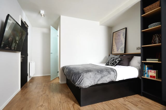 Bed with grey blanket and map art Bedroom at Vita Student Station Street in Nottingham Student Accommodation