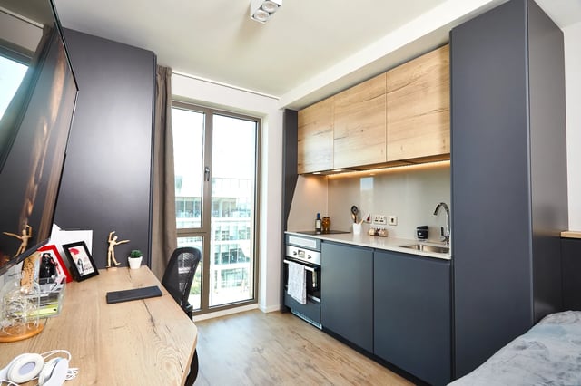 Desk tv and modern kitchen area student studio at Vita Student Station Street in Nottingham Student Accommodation