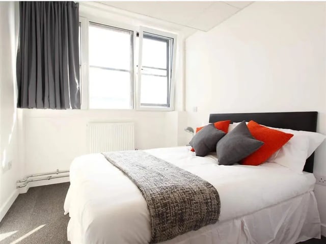 Bed with orange grey pillows and blanket bedroom at Glasgow West-End in Glasgow Student Accommodation