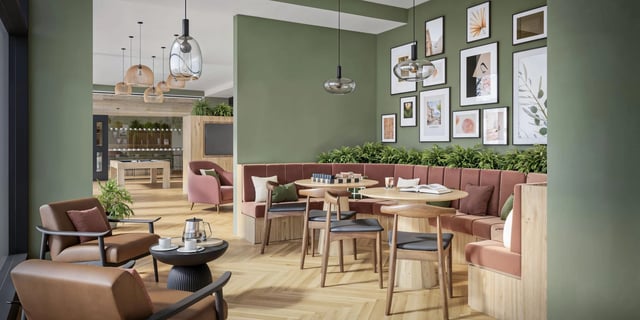 Two brown chairs tables and booths communal living room at Canvas Capital House in Southampton Student Accommodation