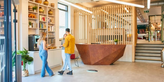 People talking by coffee machine and reception desk common area at Canvas Student - Quintana Gate in Exeter Student Accommodation