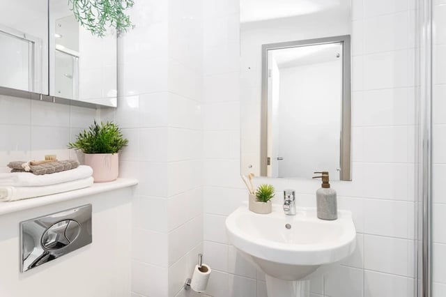 Sink mirror towels plants and toilet cistern bathroom at St Vincents Place in Sheffield Student Accommodation