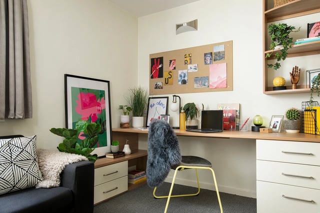 Desk with laptop plants framed art and chair study area at Moonraker Point in London Student Accommodation
