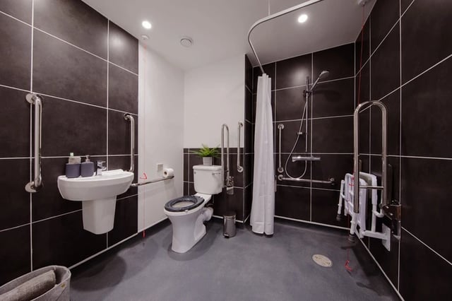 Sink toilet grab bars and shower curtain bathroom at White Rose View in Leeds Student Accommodation