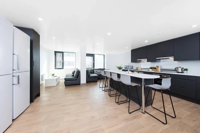 Modern kitchen and living area with island and sofas Living room at White Rose View in Leeds Student Accommodation