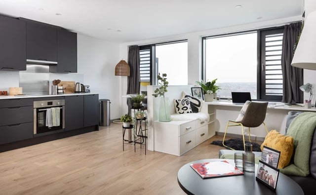 Kitchen with desk study area and living room at White Rose View in Leeds Student Accommodation